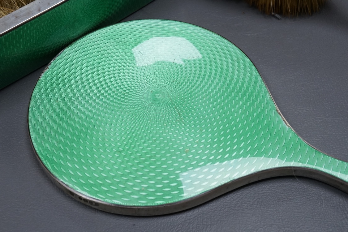 A George V silver and green guilloche enamel mounted five piece mirror and brush set, by William Neale & Son Ltd, Birmingham, 1931 (a.f.).